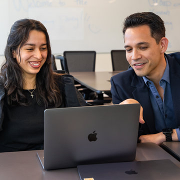 student and teacher using a laptop